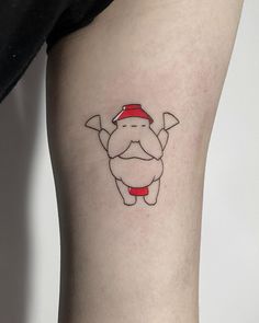 a small tattoo on the leg of a person wearing a santa hat and holding a hammer