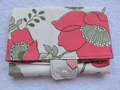 a wallet with flowers on it sitting on a towel