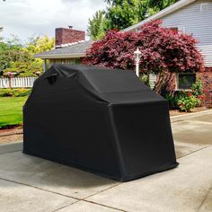 an outdoor bbq cover on the sidewalk in front of a house