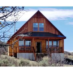 a wooden house sitting on top of a hill