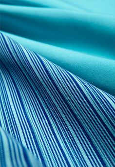 blue and white striped fabric is shown in close up view, as well as the background