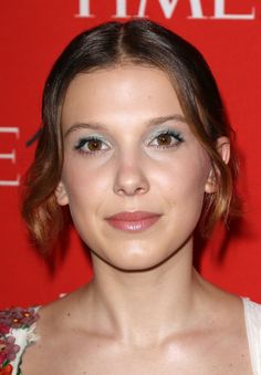 a close up of a person wearing a white dress and posing for a photo on a red carpet