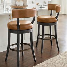 two brown stools sitting in front of a kitchen counter