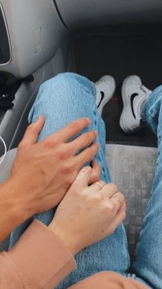 a person sitting in the back seat of a car with their hands on his knees