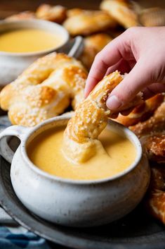 a person dipping some food into a bowl