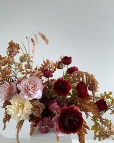 a vase filled with lots of flowers on top of a table