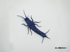 a blue insect sitting on top of a white surface