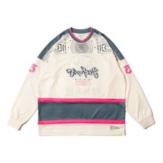 a white sweater with pink and blue trims on the sleeves, featuring an image of a