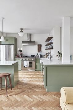 a kitchen with green cabinets and wooden floors