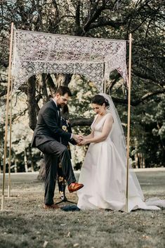 the bride and groom are getting ready to exchange their vows under an old - fashioned lace covered chute