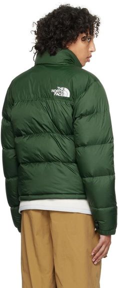 The North Face.Green 1996 Retro Nuptse Down Jacket.RDS-certified down-filled quilted non-PFC DWR-coated recycled nylon ripstop and taffeta jacket. Packable and water-repellent..· Stowable hood at funnel neck.· VISLON® zip closure.· Logo embroidered at chest and back.· Zip pockets.· Bungee-style drawstring at hem.· Triclimate® loop and velcro tab at elasticized cuffs.· Zip pocket at interior.· Full taffeta lining.Supplier color: Pine needles.Fill: 85% down, 15% waterfowl feathers..Body: 100% recycled nylon. Lining: 100% nylon..Made in Bangladesh..232802F061031 Green Down Puffer Jacket For Streetwear, Green Down Puffer Jacket With Padded Collar, The North Face Nylon Puffer Jacket With Pockets, Green Down Outerwear For Hiking, Green Down Puffer Jacket For Outdoor, Green Down Puffer Jacket For Outdoor Activities, Taffeta Jacket, North Face Outfits, Pine Needles