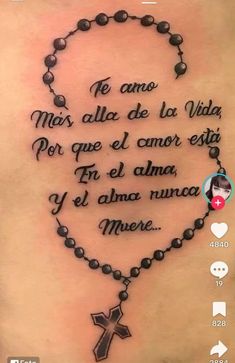 the back of a woman's stomach with a rosary and cross tattoo on it