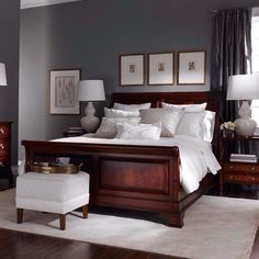 a bedroom with gray walls and white bedding