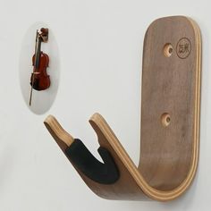 a violin hanger next to a wall with a violin on it