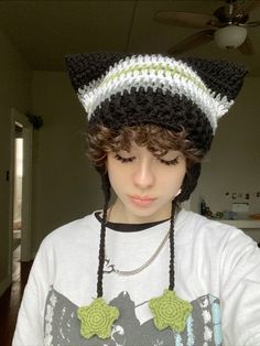 a young boy wearing a cat hat and necklace