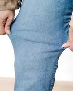 These jeans are high-waisted, bootcut style with a medium-wash blue denim. The denim has a subtle faded effect along the thighs and knees, giving them a slightly worn-in look. They are fitted through the hips and thighs, then gently flare out below the knee, providing a flattering silhouette. The back pockets have a classic, simple design without any embellishments or stitching details, maintaining a clean, streamlined appearance. The overall style has a retro-inspired, classic vibe, ideal for pairing with casual or semi-dressy outfits. Classic Vibe, Stitching Details, Dressy Outfits, Boot Cut Jeans, Cut Jeans, Retro Inspired, Simple Design, The Knee, Simple Designs