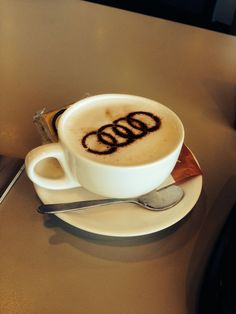 a white cup filled with liquid sitting on top of a saucer