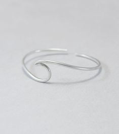 Wave cuff bangle, sterling silver, beach jewellery, ocean, beach bracelet, minimalist, adjustable, gift for her, one size Sterling silver solid cuff hand formed to a wave shape from 12 gauge (2 mm) wire. Comfortable to wear all day or sleep with and sturdy. This bangle is slightly adjustable and thus one size. It will fit most wrists (14 -18 cm / 5.5 - 7 inches wrist). But you can always ask for a different size. The bracelet above is not the exact one you will receive. Each one is handmade to o Silver Dainty Bracelets For Beach, Dainty Silver Bracelets For The Beach, Minimalist Resizable Bracelets For Beach, Minimalist Beach Bracelets, Silver Minimalist Resizable Bracelet, Minimalist Silver Resizable Bracelet, Silver Minimalist Bracelets For The Beach, Minimalist Beach Bracelet Jewelry, Minimalist Sterling Silver Jewelry For Beach