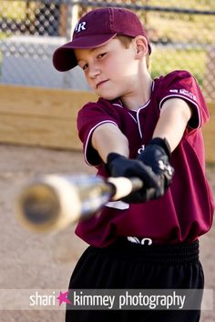 a young boy swinging a baseball bat at a ball