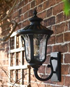 an outdoor light on the side of a brick wall