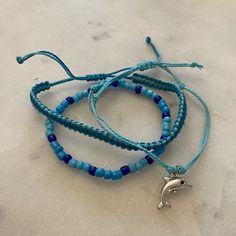 Set Of 3 Bracelets With Dolphin Charm 6.3-10 Inch Circumference Waterproof And Fade Proof! Trendy Blue Braided Bracelet With Sliding Knot, Adjustable Blue Friendship Bracelet, Trendy Blue Jewelry With Sliding Knot, Trendy Adjustable Blue Braided Bracelet, Trendy Blue Hypoallergenic Friendship Bracelets, Adjustable Trendy Blue Bracelets, Blue Trendy Hypoallergenic Friendship Bracelet, Trendy Adjustable Blue Bracelets, Trendy Blue Hypoallergenic Friendship Bracelet