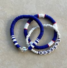 These handmade stackable baseball bracelets get you ready for game day!  Price includes THREE bracelets. Can also add last name, number, etc. If you want to customize your stack, please message me! Made with Heishi beads, seed beads, rhinestone beads and high quality stretchable string for durability. Ships within the normal 1-3 business days.  Size 6 fits kids, size 6.5 fits small wrists and size 7 fits most. If a larger size is needed, please let us know (measure wrist tightly with no slack, adding .5" to find your perfect fit). Message for custom orders at no additional charge. Let me know your team color and any personalizations.  CARING TIPS: These bracelets are made with quality stretch cord, but are still delicate. Please be careful when taking them on and off. Rolling is best. For Sandlot Bracelet Ideas, Yankees Clay Bead Bracelet, Dodgers Bracelet, Astros Bracelet, Baseball Bracelet Diy, Houston Astros Bracelet, Baseball Mom Bracelet, Team Bracelets, Gifts For Baseball Lovers