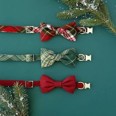 three bow ties are lined up on a green surface with pine branches in the background