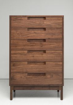 a wooden chest of drawers sitting on top of a white floor