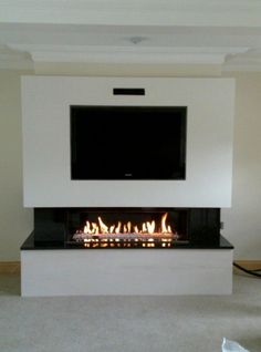 a flat screen tv mounted on the wall above a fireplace