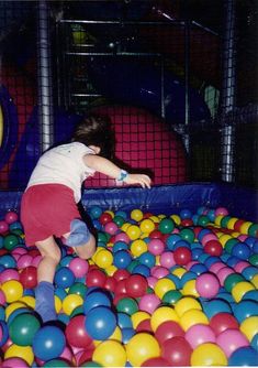 a young child playing in a ball pit