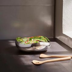 two wooden spoons sitting on top of a bowl