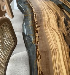 a close up of a wooden table with chairs in the background and an abstract design on it