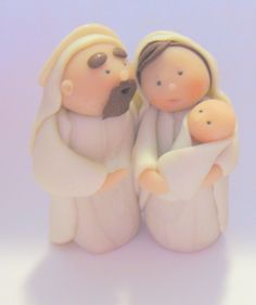 a ceramic figurine of two people holding a baby