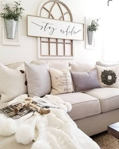 a living room filled with furniture and pillows on top of a white couch next to a window