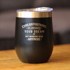 there is a black wine glass with gold rim on the table and it says congratulations on producing your dream or not working here anymore