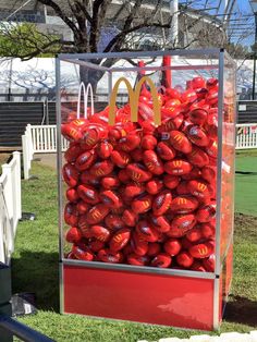 a pile of mcdonald's bags sitting on top of a red carton in the grass