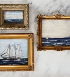 three framed paintings depicting sailboats on a marble wall with gold trim around the edges