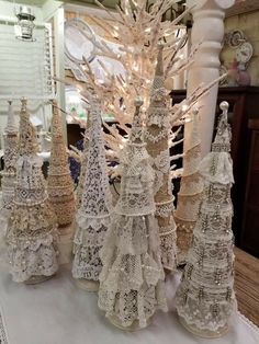 several white christmas trees are sitting on a table