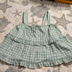 Nwt. Pale Green And White Plaid Multi Ruffled Top With Wide Straps On Shoulders. Has Accent Tie In Front Of Shirt. Very Cute. Cotton Ruffle Hem Top For Vacation, Cotton Tops With Ruffle Hem For Vacation, Cotton Top With Ruffle Hem For Vacation, Green Ruffle Hem Tops For Summer, Gingham Ruffle Tops For Vacation, Gingham Ruffled Tops For Vacation, Cotton Ruffle Blouse For Vacation, Beach Cotton Top With Ruffle Hem, Cotton Beach Top With Ruffle Hem