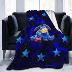 a blue blanket with a cartoon character sitting on top of it, surrounded by stars