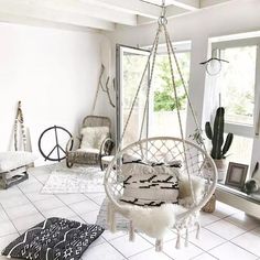 a living room filled with lots of furniture and decor on top of white tile flooring