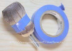 a pair of blue tape is next to a piece of wood and a metal tool