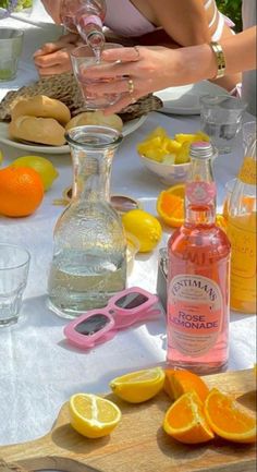 a table with oranges, lemons and bottles of alcohol sitting on top of it