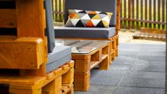 two wooden chairs sitting next to each other on a patio