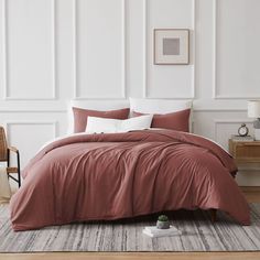 a bedroom with white walls and purple comforter on the bed in front of it