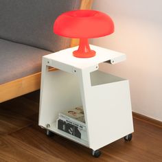 a small white table with a red lamp on top