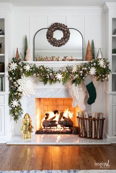 a fireplace decorated for christmas with stockings and wreaths