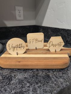 two wooden signs that say vegetables and bread sit on a counter top next to a computer mouse