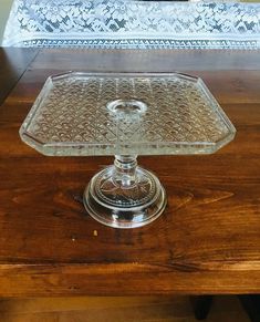 a glass cake plate sitting on top of a wooden table