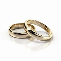 two gold wedding rings sitting next to each other